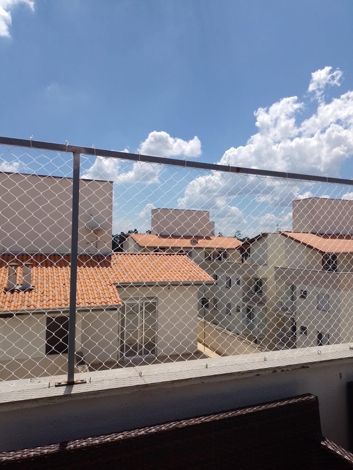 Rede de proteção em varanda de casa com vista do bairro